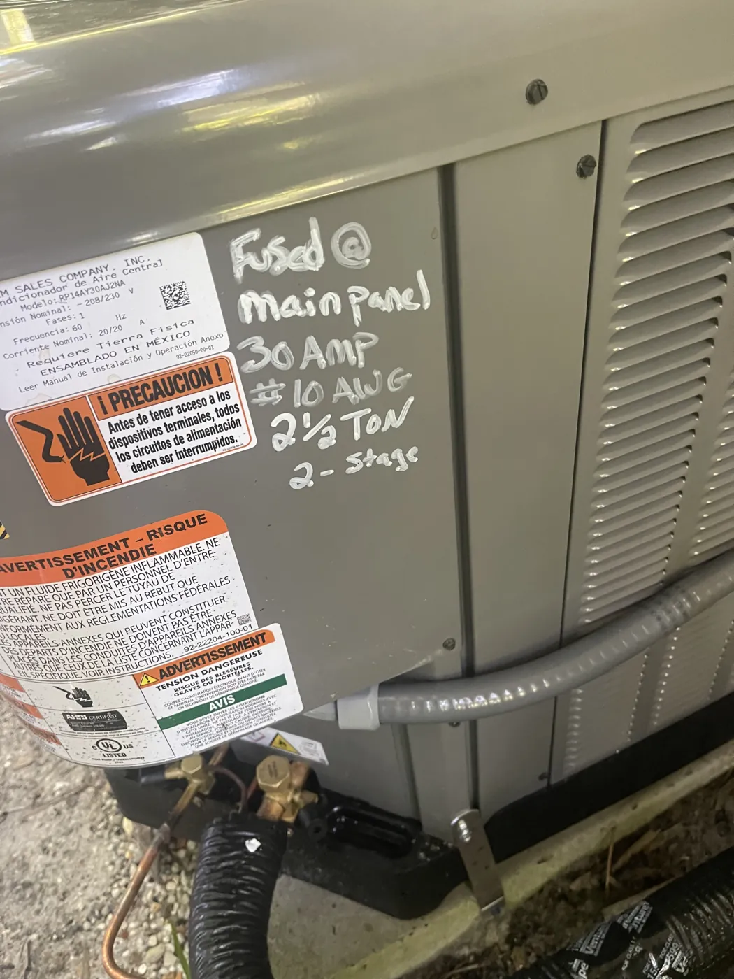 Commissioning notes handwritten on a new condenser, marking it two and a half tons and two-stage